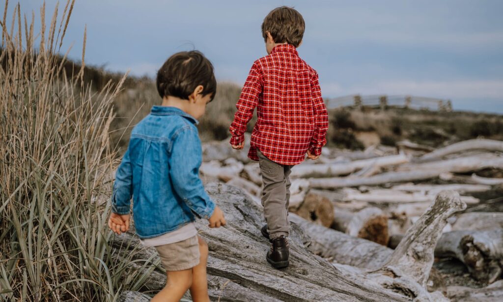 kids walking on driftwood 